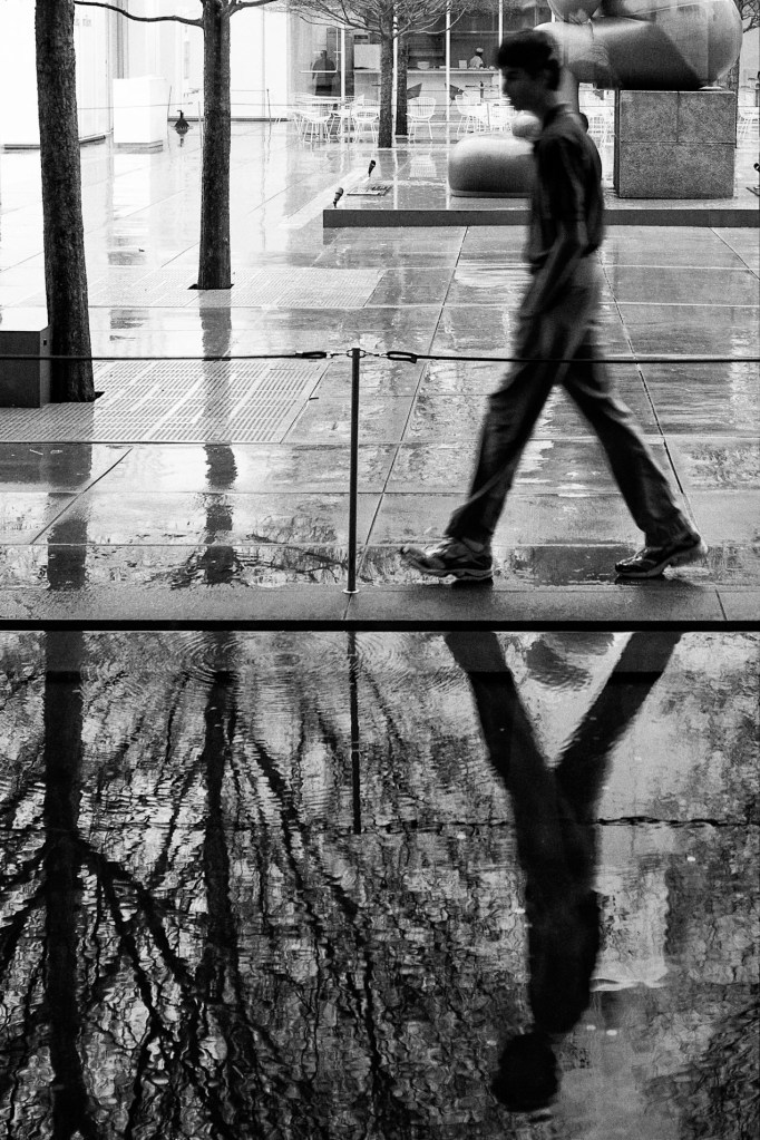 Man walking in rain at High Museum, Atlanta, Georgia.